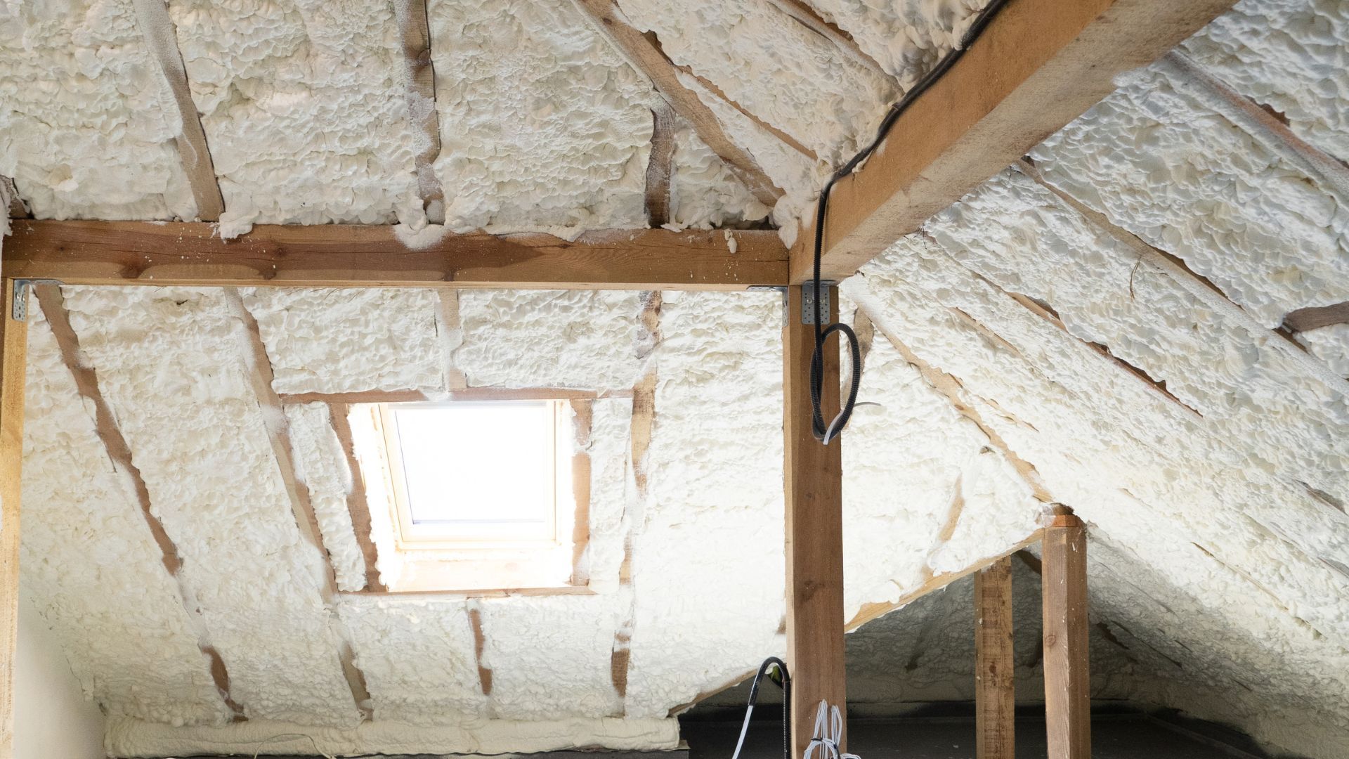 Finished attic spray foam insulation applied evenly along the roofline for improved energy efficiency and indoor comfort.