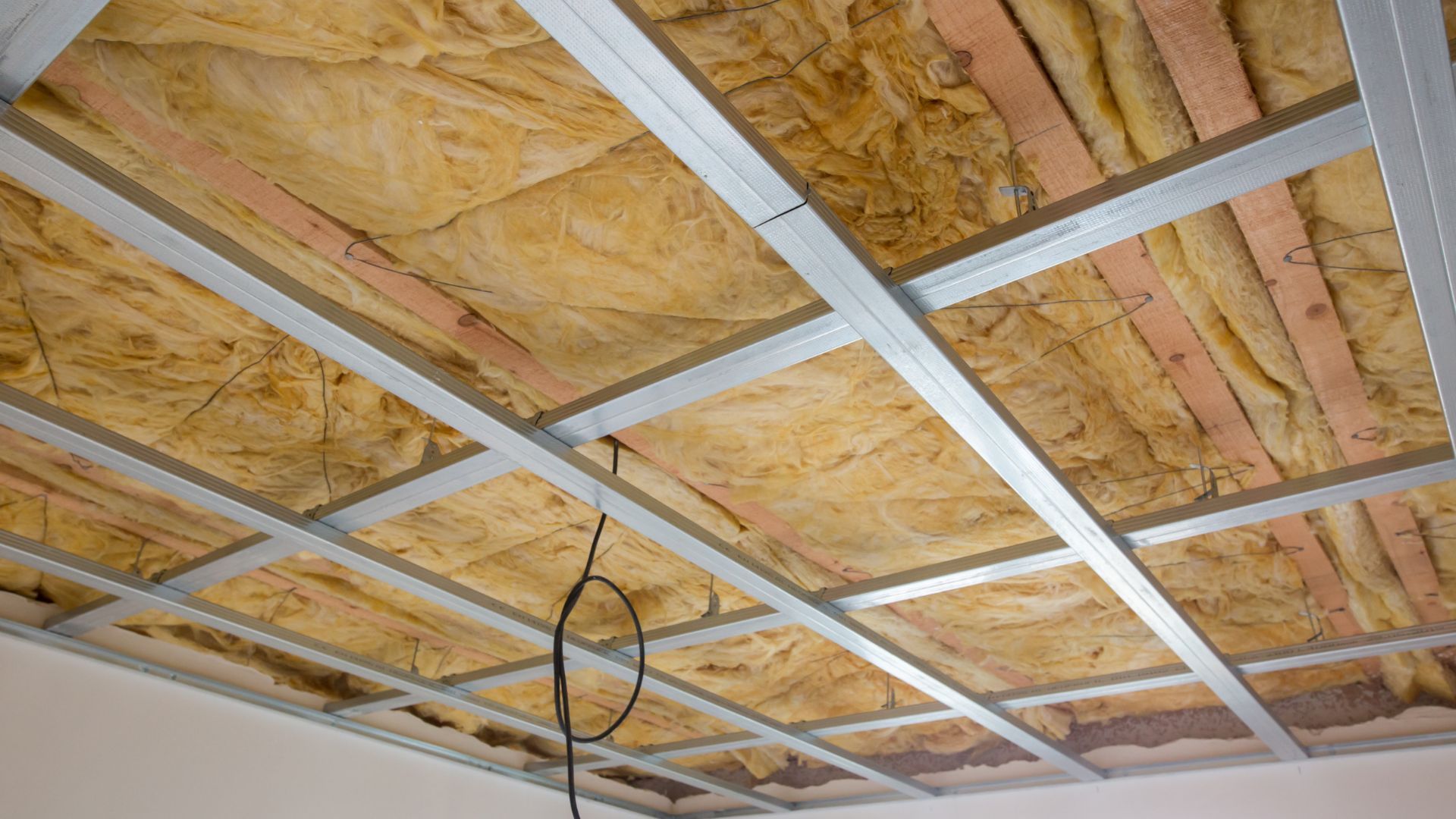 Metal building attic with spray foam insulation evenly applied beneath the metal roof panels for improved thermal performance.