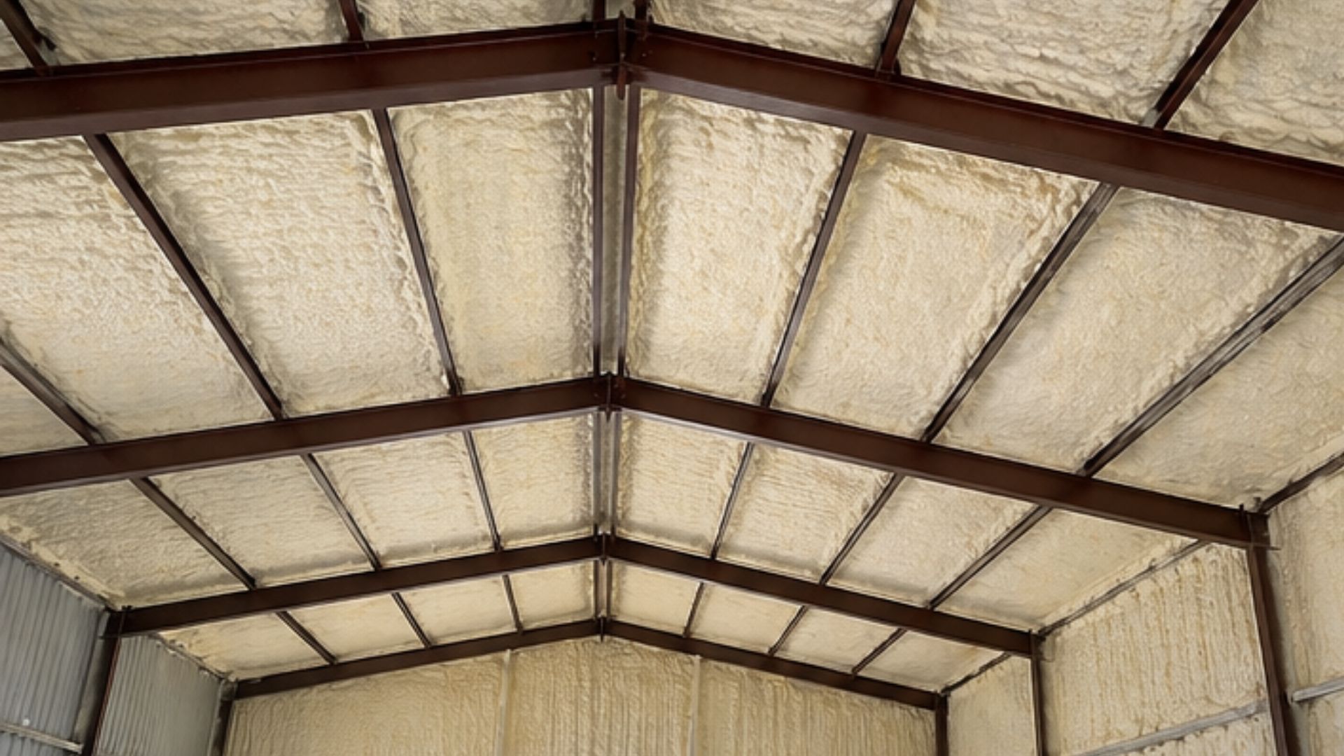 Completed metal building spray foam insulation in Tyler, Texas, featuring insulated steel walls and ceiling, exposed structural beams, and a spacious commercial interior.