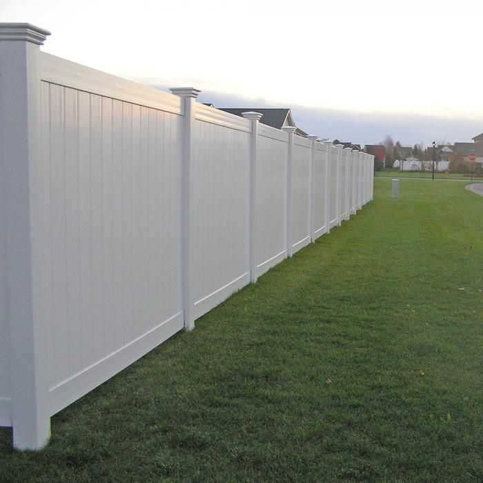 White vinyl privacy fence in a grassy yard.