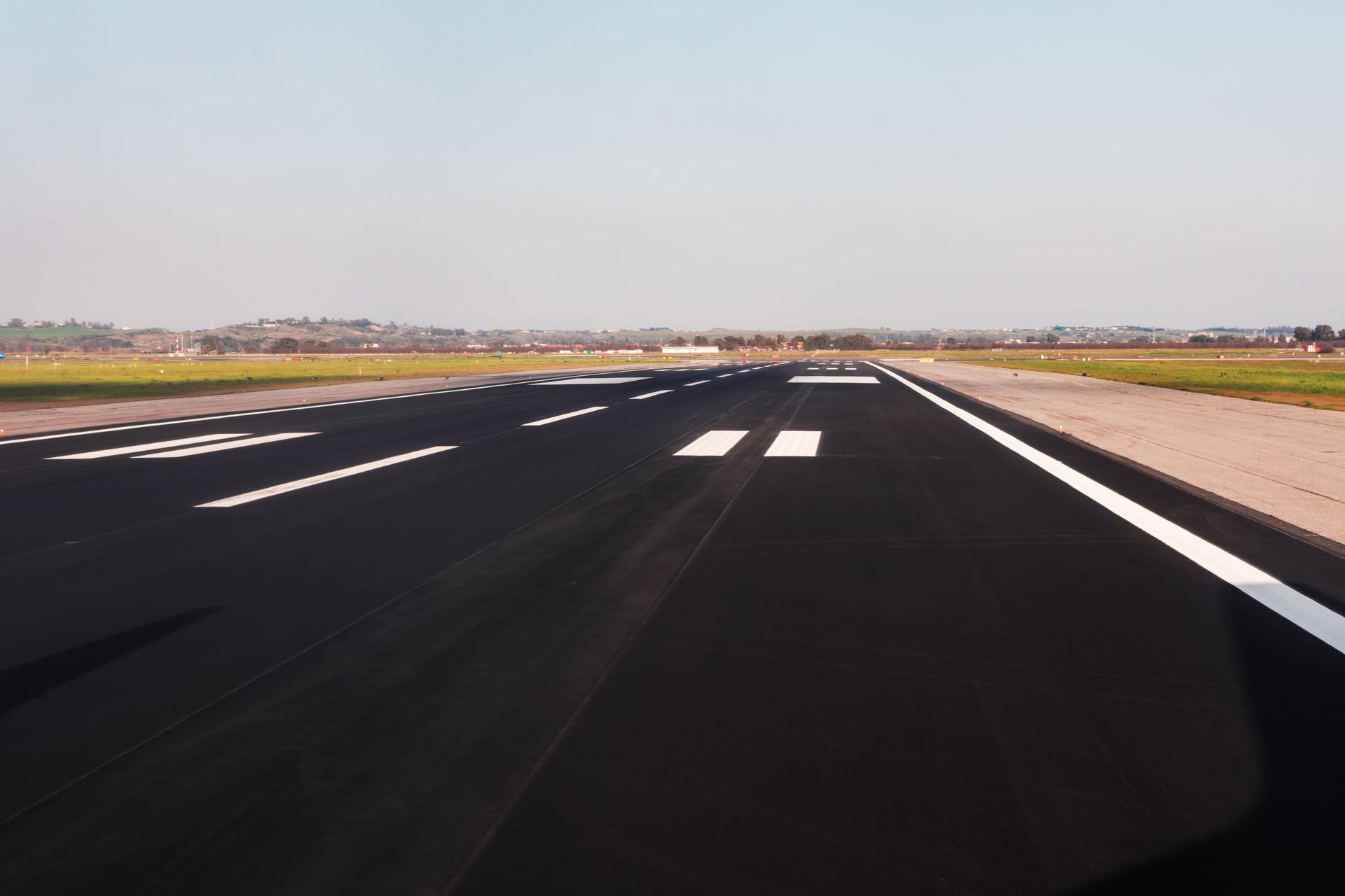 Commercial airplane approaches for landing on freshly paved airport runway. Commercial airplane approaches for landing on freshly paved airport runway.