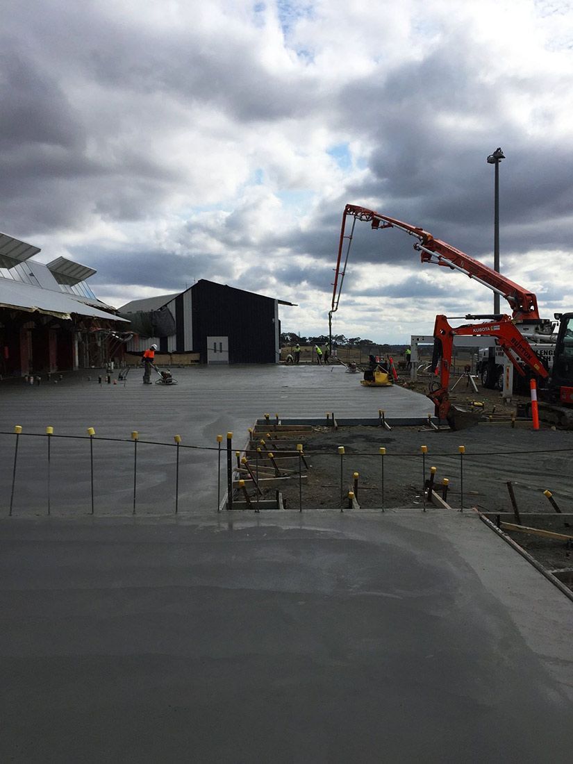 A Concrete Pump is Being Used to Pour Concrete Into a Parking Lot — Heritage Concrete In Uralla, NSW