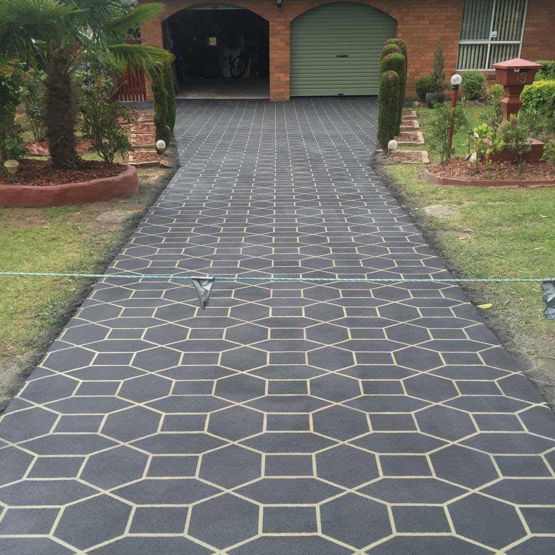 A Driveway Leading to a Brick House With a Green Garage Door — Heritage Concrete In Uralla, NSW