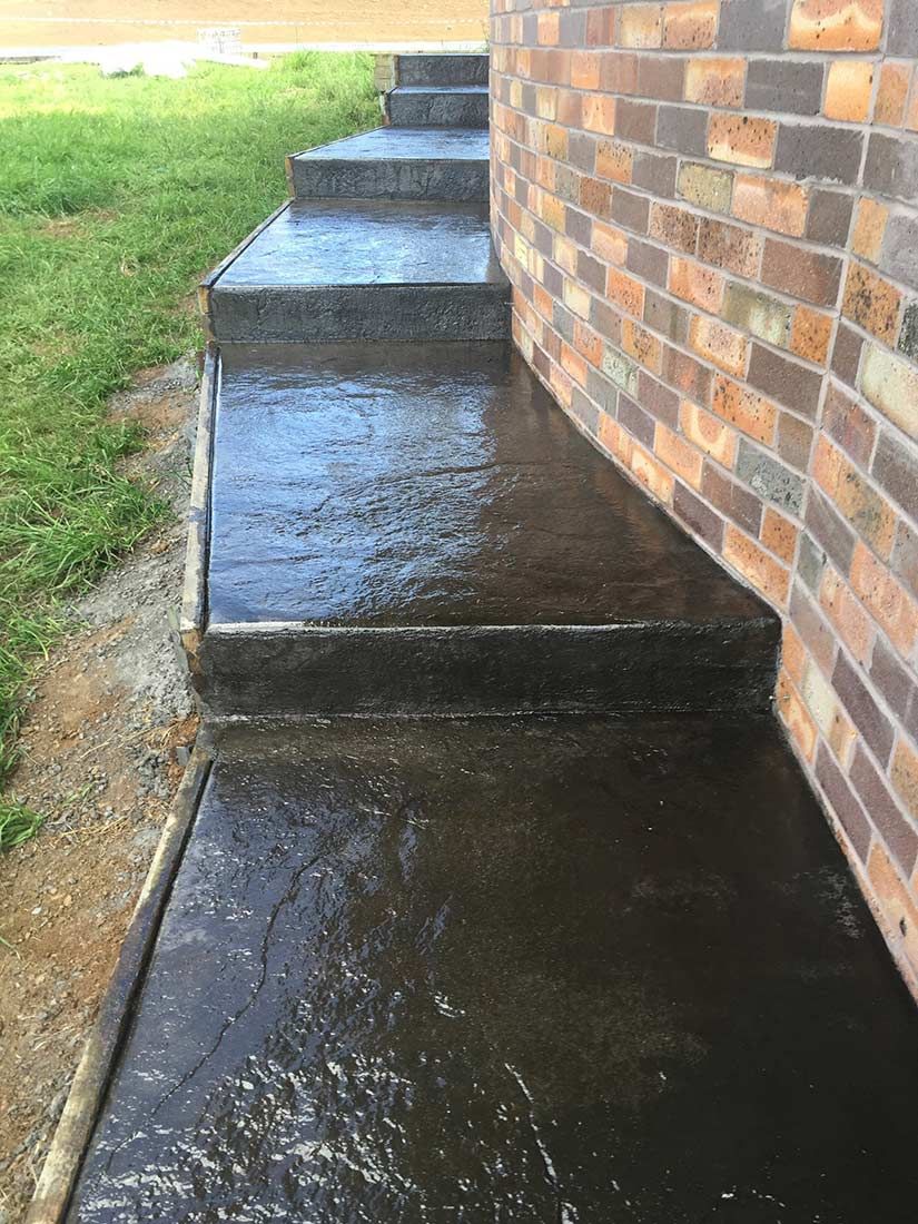 A Set of Concrete Steps Leading Up to a Brick Building — Heritage Concrete In Uralla, NSW
