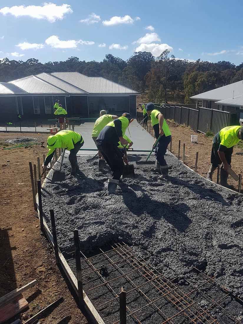 A Group of Construction Workers Are Working on a Concrete Slab — Heritage Concrete In Uralla, NSW