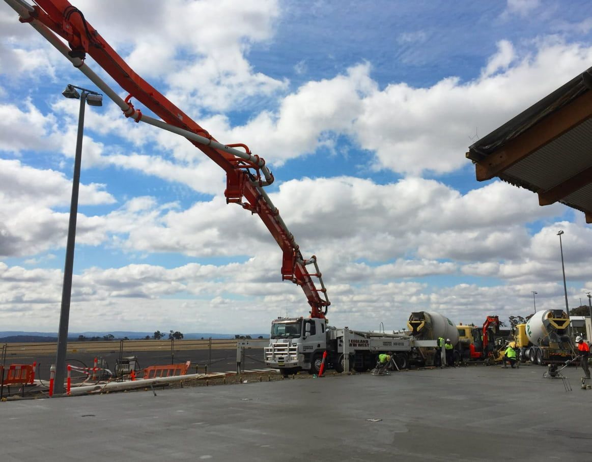 A Concrete Pump Is Being Used To Pour Concrete Into A Parking Lot — Heritage Concrete In Uralla, NSW