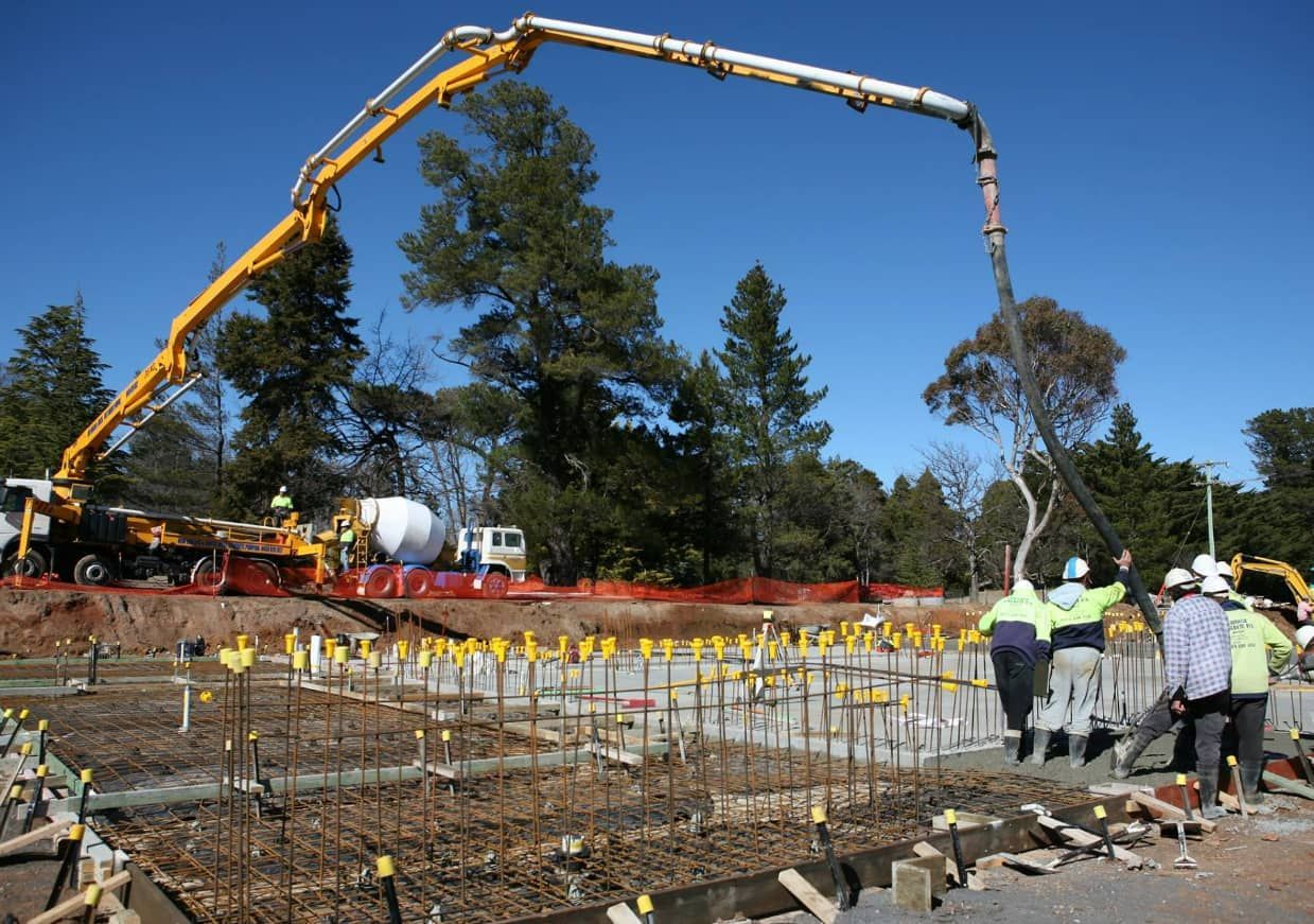 A Concrete Pump Is Being Used To Pour Concrete On A Construction Site — Heritage Concrete In Armidale, NSW