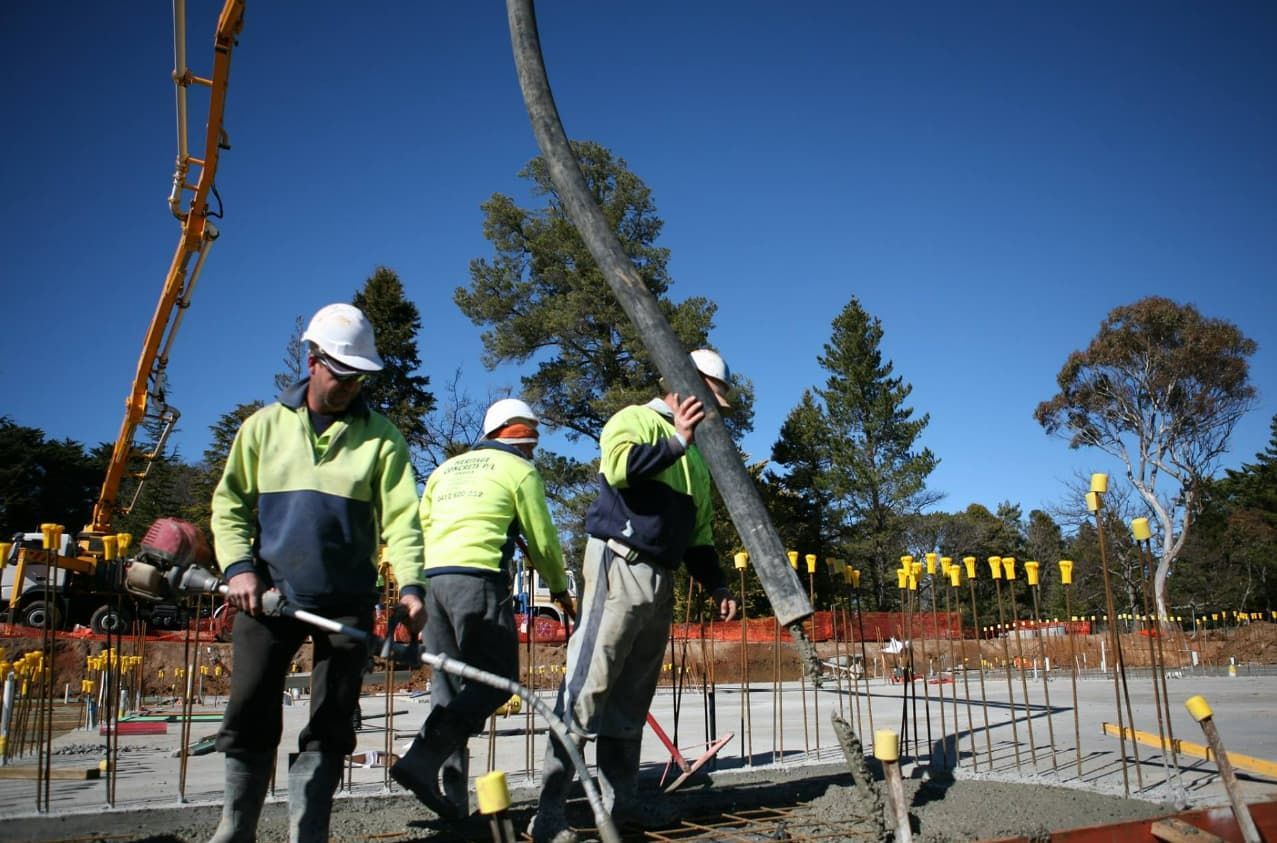 A Group Of Construction Workers Are Working On A Construction Site — Heritage Concrete In Uralla, NSW