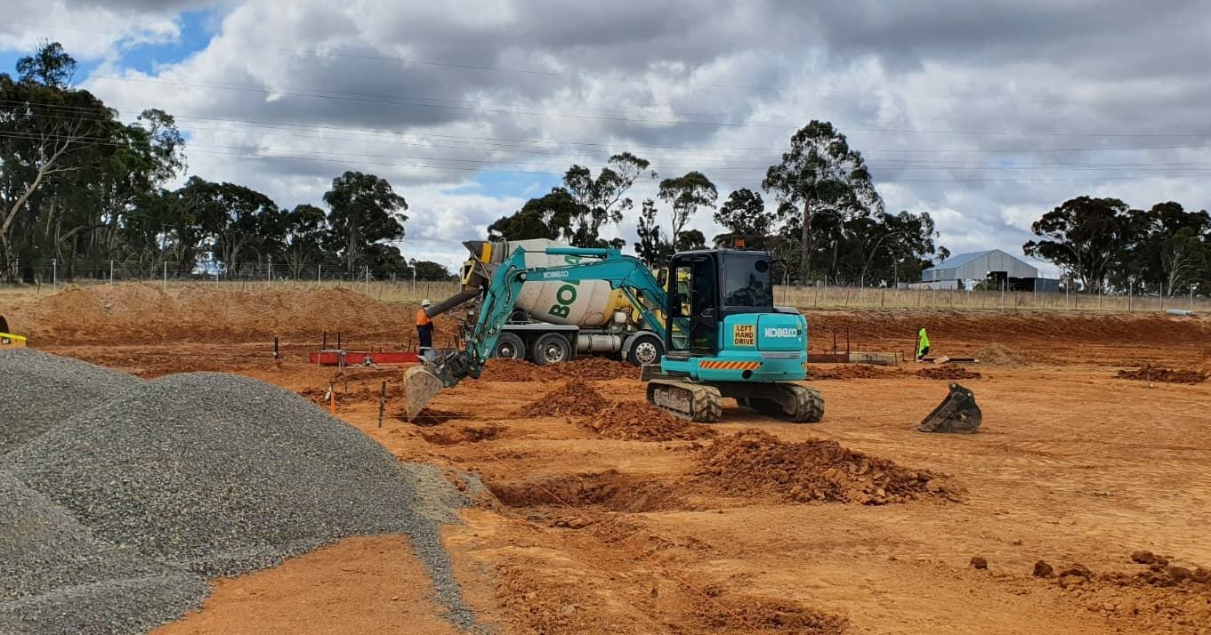 A Construction Site With A Bulldozer And A Truck — Heritage Concrete In Uralla, NSW