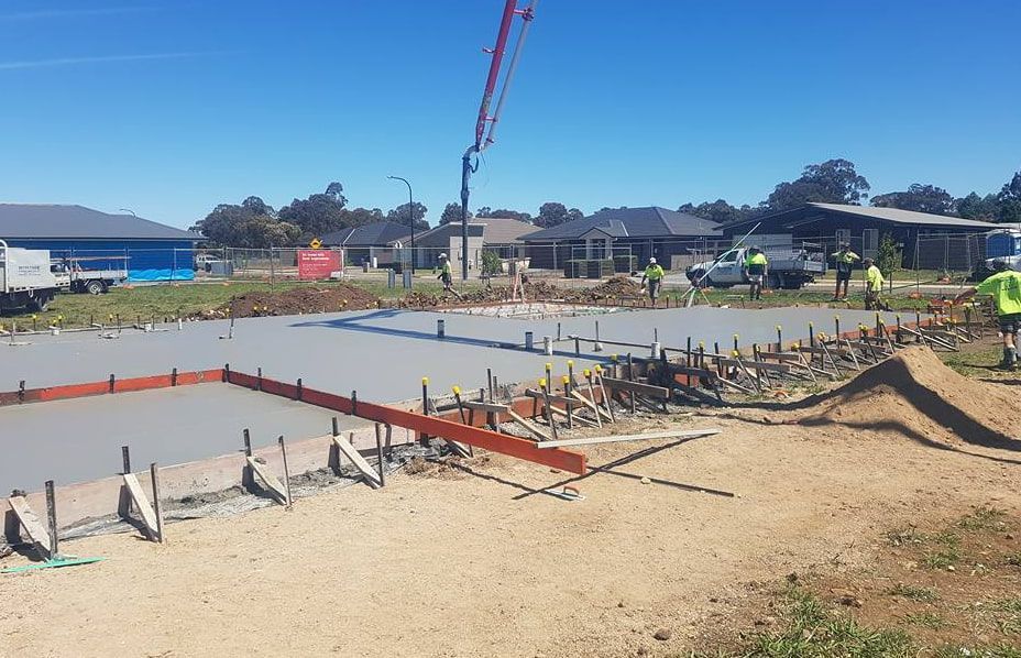 A Concrete Pump is Being Used to Pour Concrete on a Construction Site — Heritage Concrete In Uralla, NSW