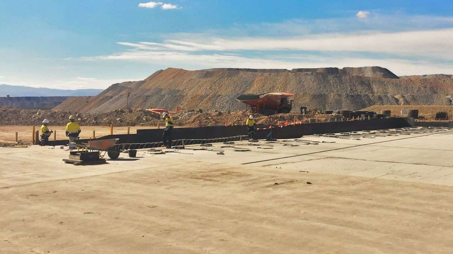 A Group Of Construction Workers Are Working On A Large Dirt Field — Heritage Concrete In Uralla, NSW