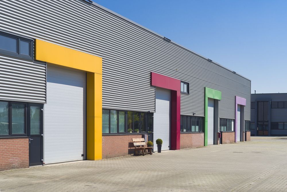 Warehouse Exterior with Colorful Door Frames — Hi Tech Roofing in Kilaben Bay, NSW