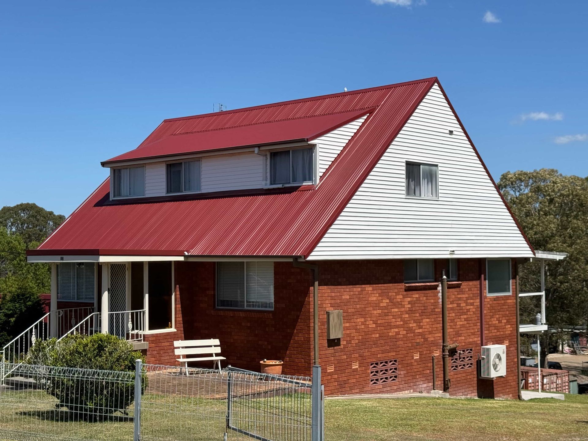 Black Metal Tile Roof with Dark Trim and A Green Tree Backdrop — Hi Tech Roofing in Port Stephens, NSW
