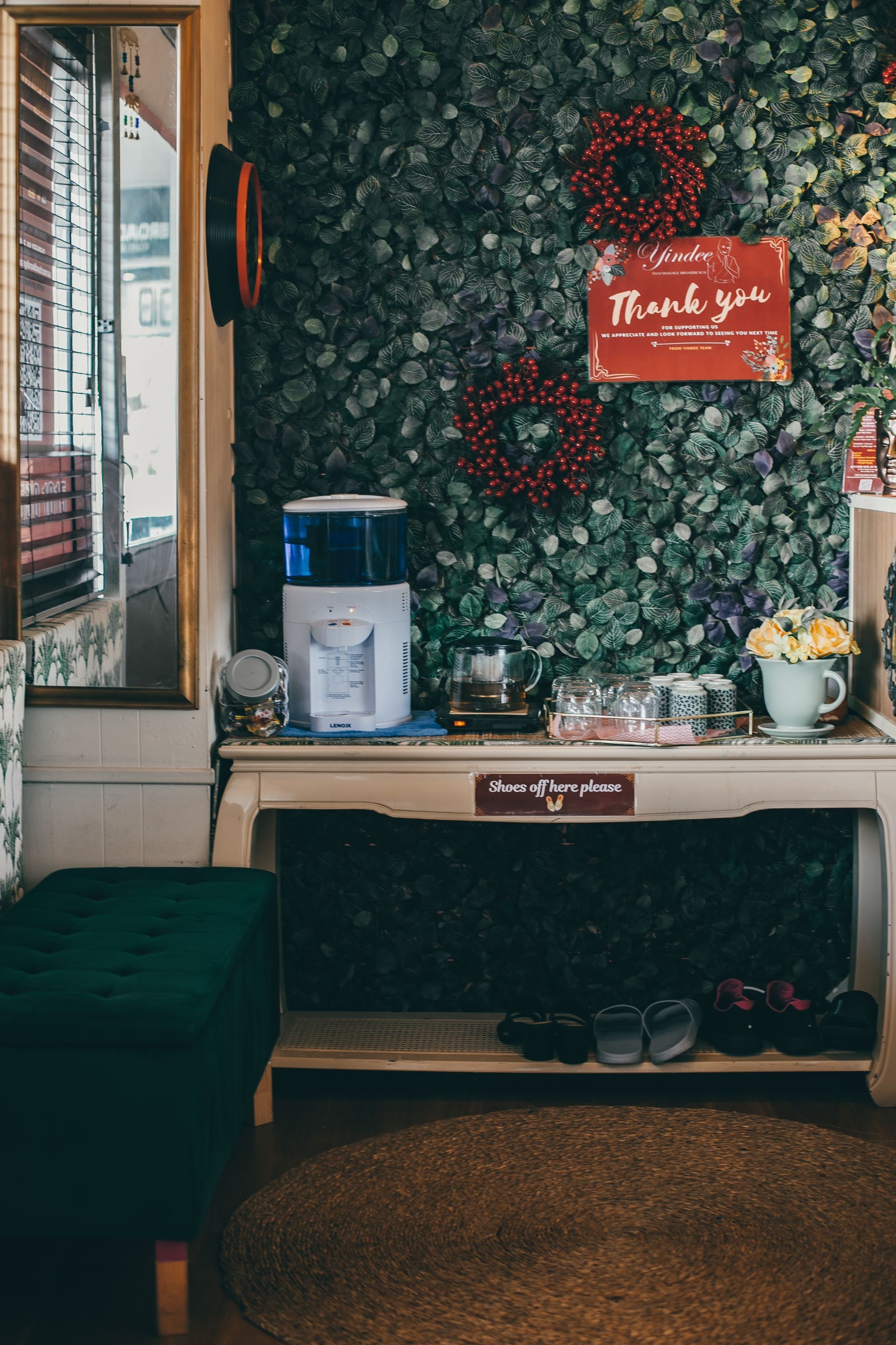 Self-serve beverage station with water dispenser, tea, glasses, and