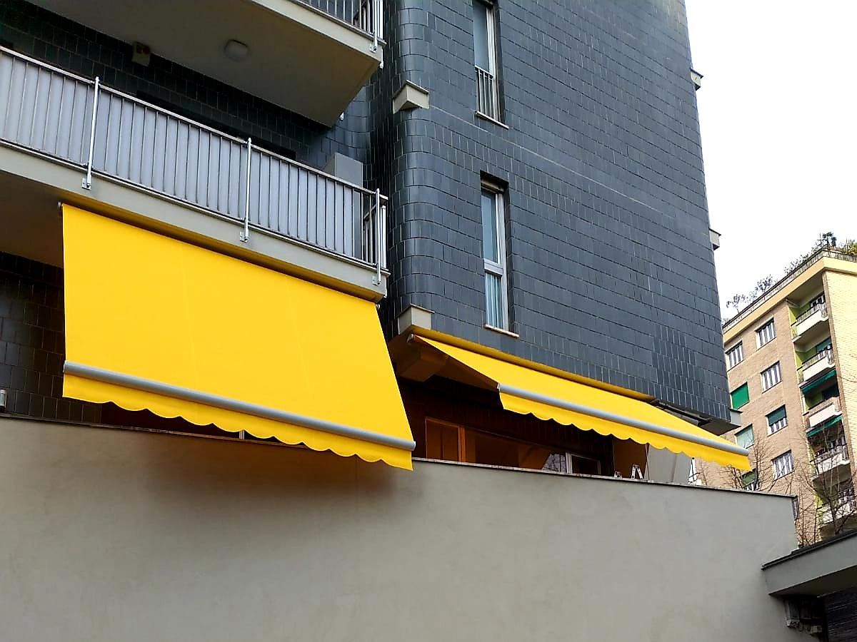 Tende gialle su un edificio scuro, che creano ombra.