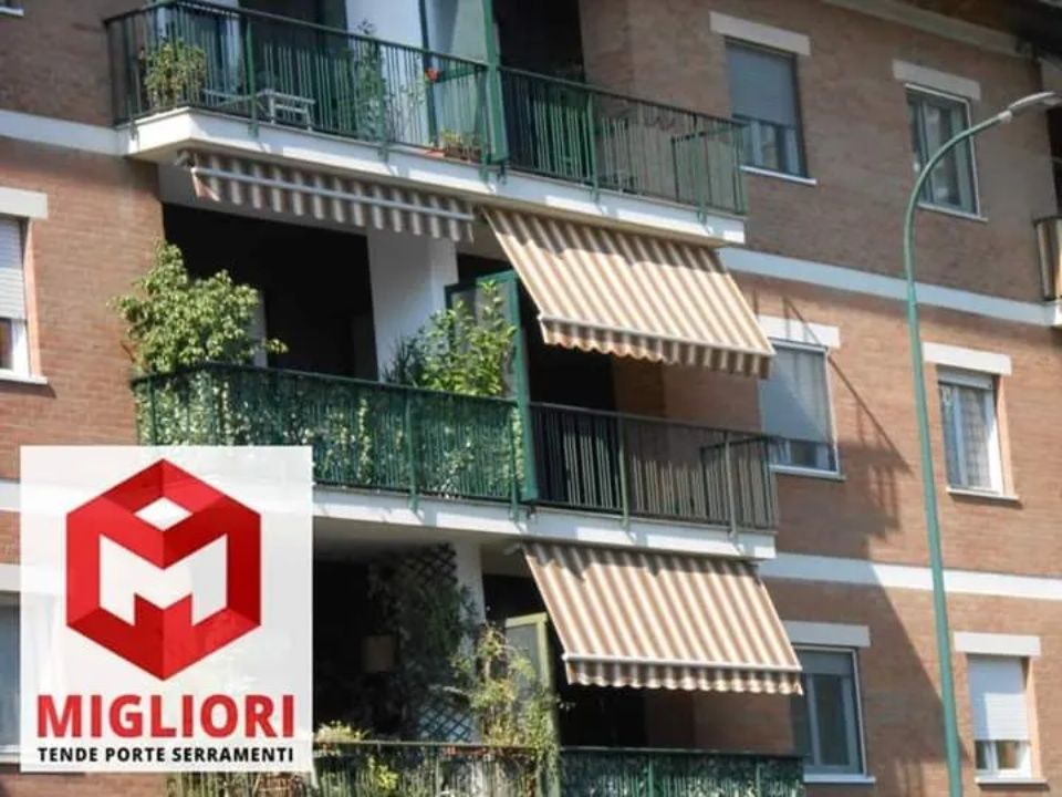 Tende da sole per balconi su un edificio in mattoni con il logo