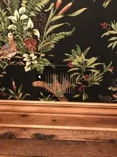 A picture of a wall with a picture of birds and flowers on it.