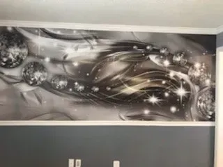 A black and white painting of a woman 's face on a wall.