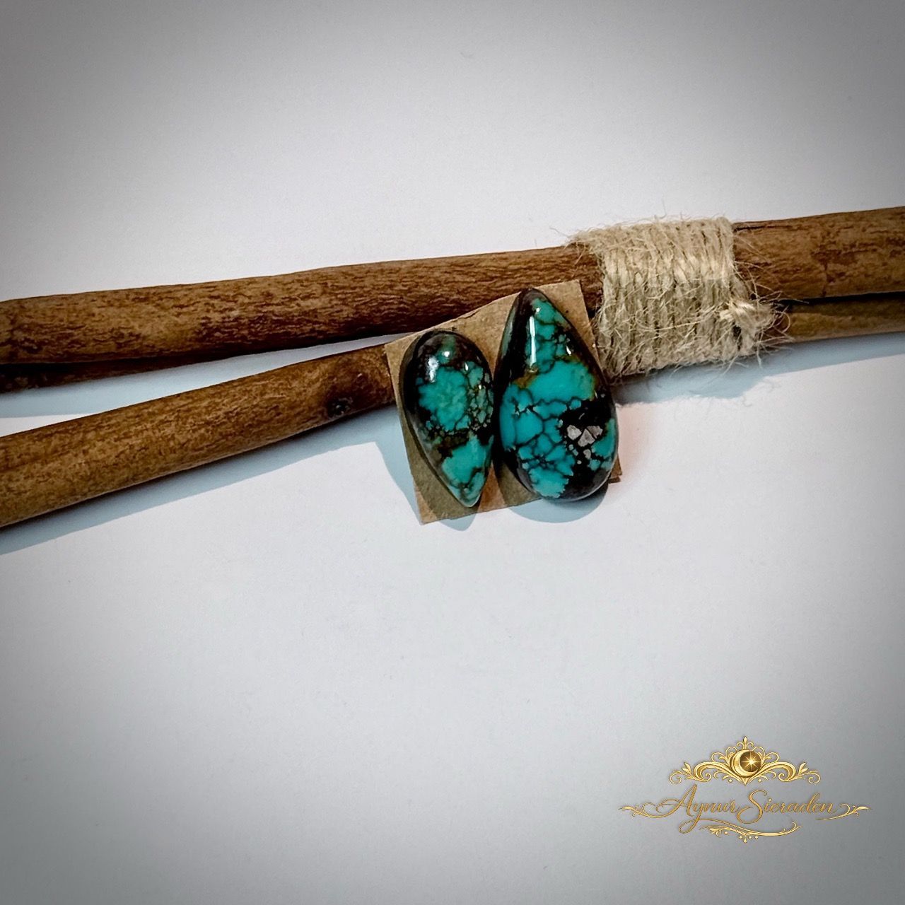 Kingman turkoois cabochons naast elkaar op houten achtergrond – unieke blauwgroene tinten met matrix patroon