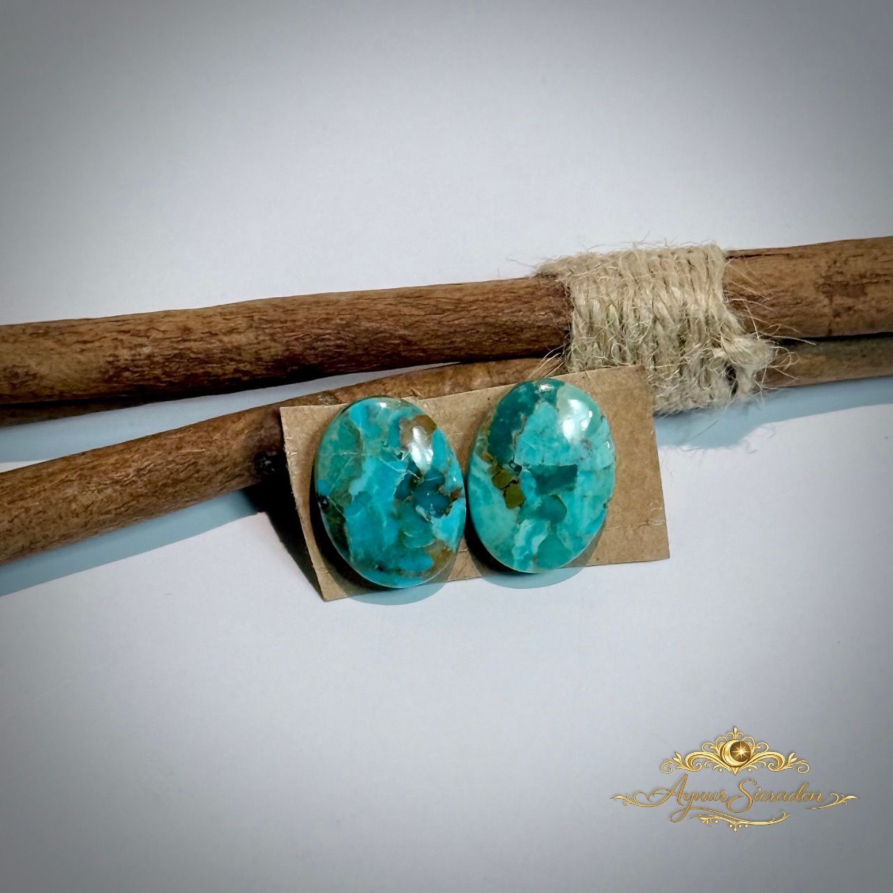 Kingman turkoois ovaal cabochon paar op houten tak – blauwgroene stenen met natuurlijke matrix, handgeslepen