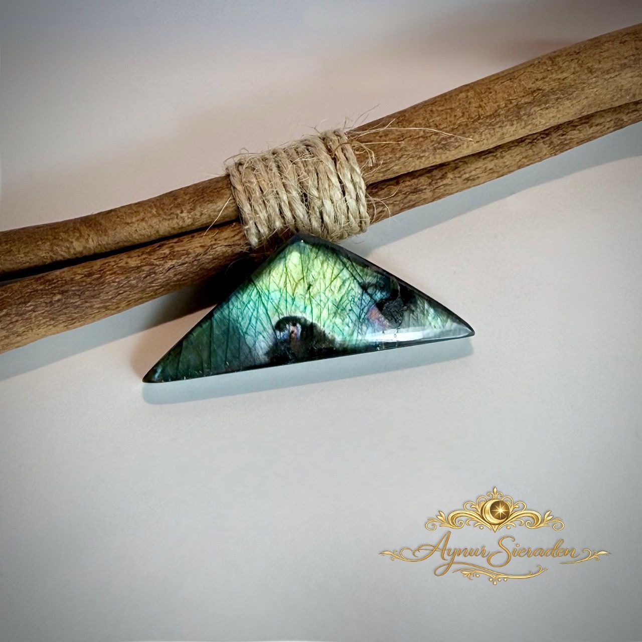 Driehoekige labradoriet cabochon met groen-blauwe labradorescentie.