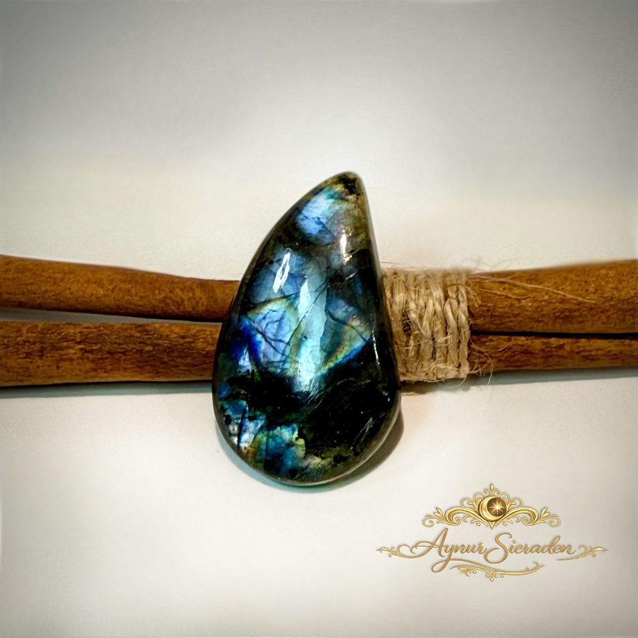 Labradoriet cabochon in vrije druppelvorm met blauwe en gouden glans.