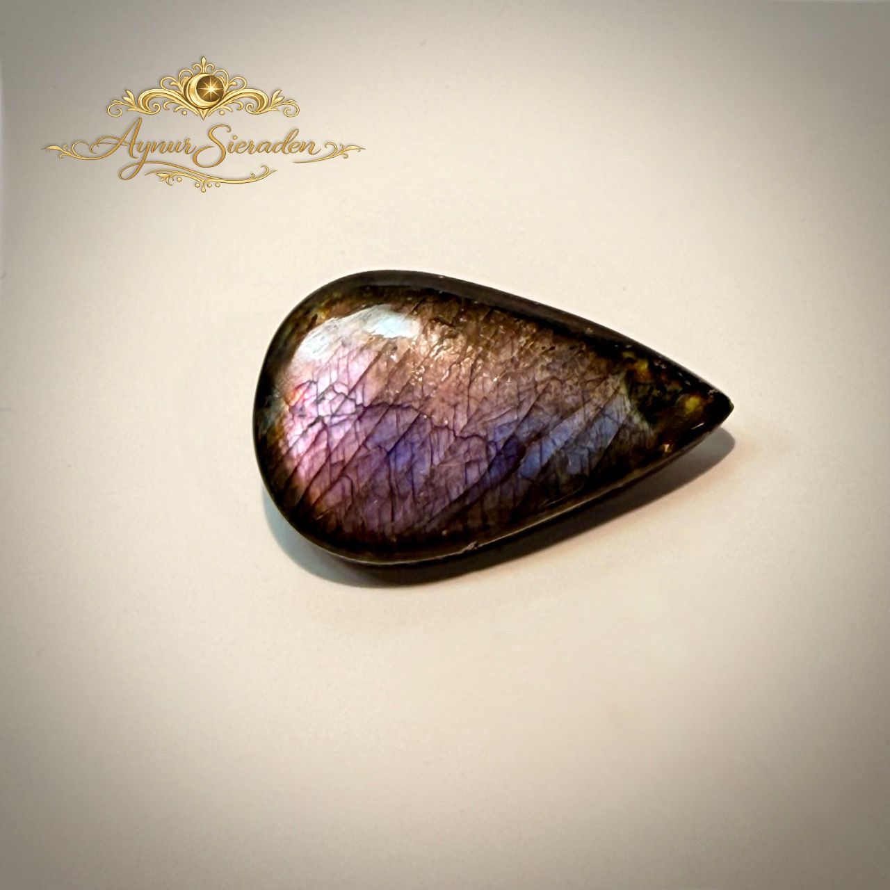 Handgeslepen labradoriet cabochon met romantisch kleurenspel voor exclusieve sieraden.