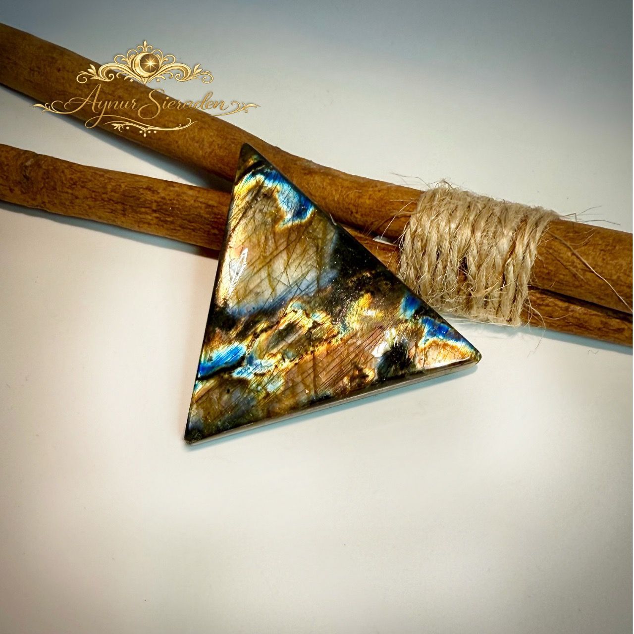 Driehoekige labradoriet cabochon met gouden en blauwe glans.