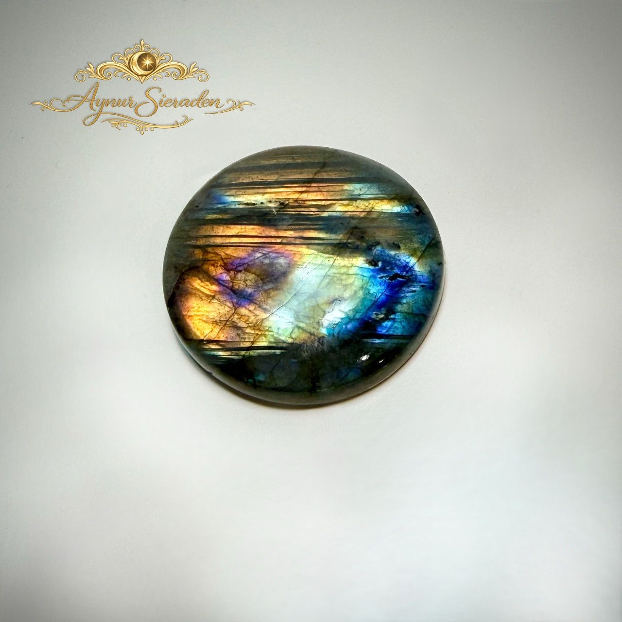 Unieke ronde labradoriet cabochon geschikt voor exclusieve handgemaakte sieraden.