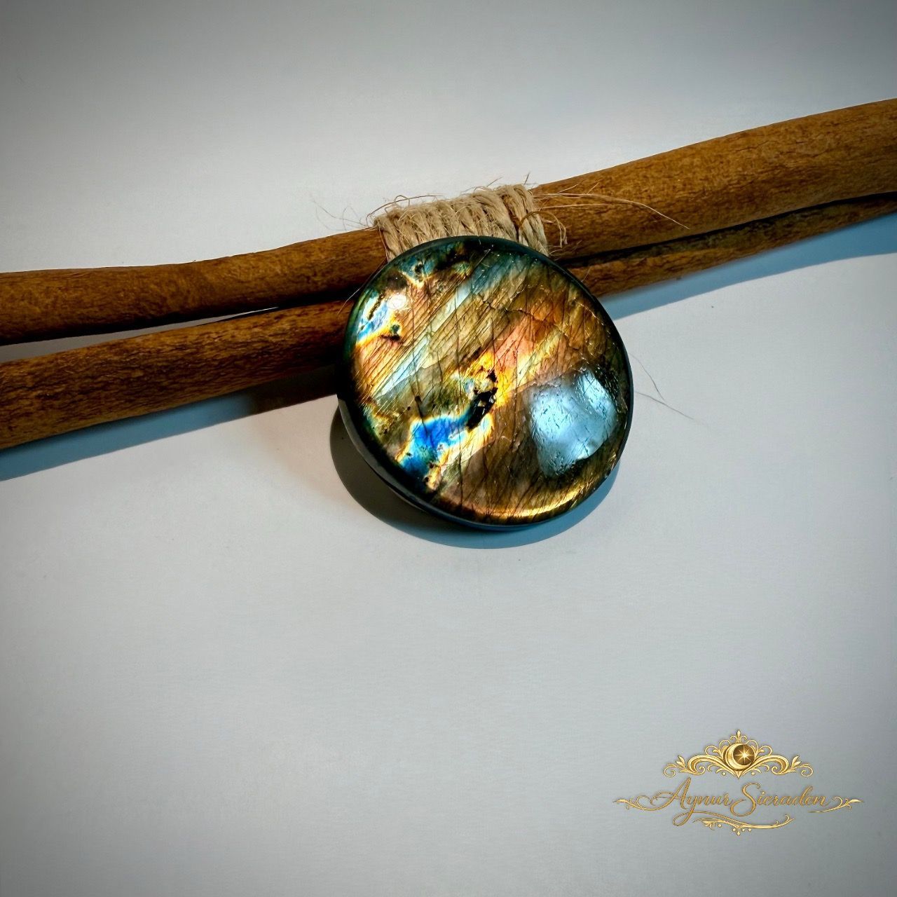 Ronde labradoriet cabochon met gouden en blauwe flash op houten achtergrond