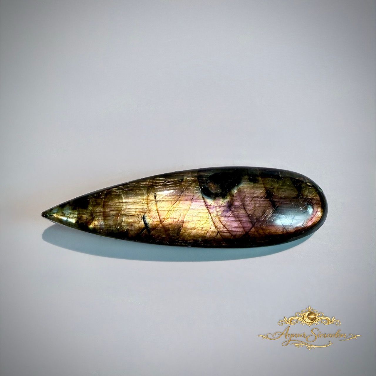 Langwerpige labradoriet cabochon met paarse en gouden flash voor handgemaakte sieraden