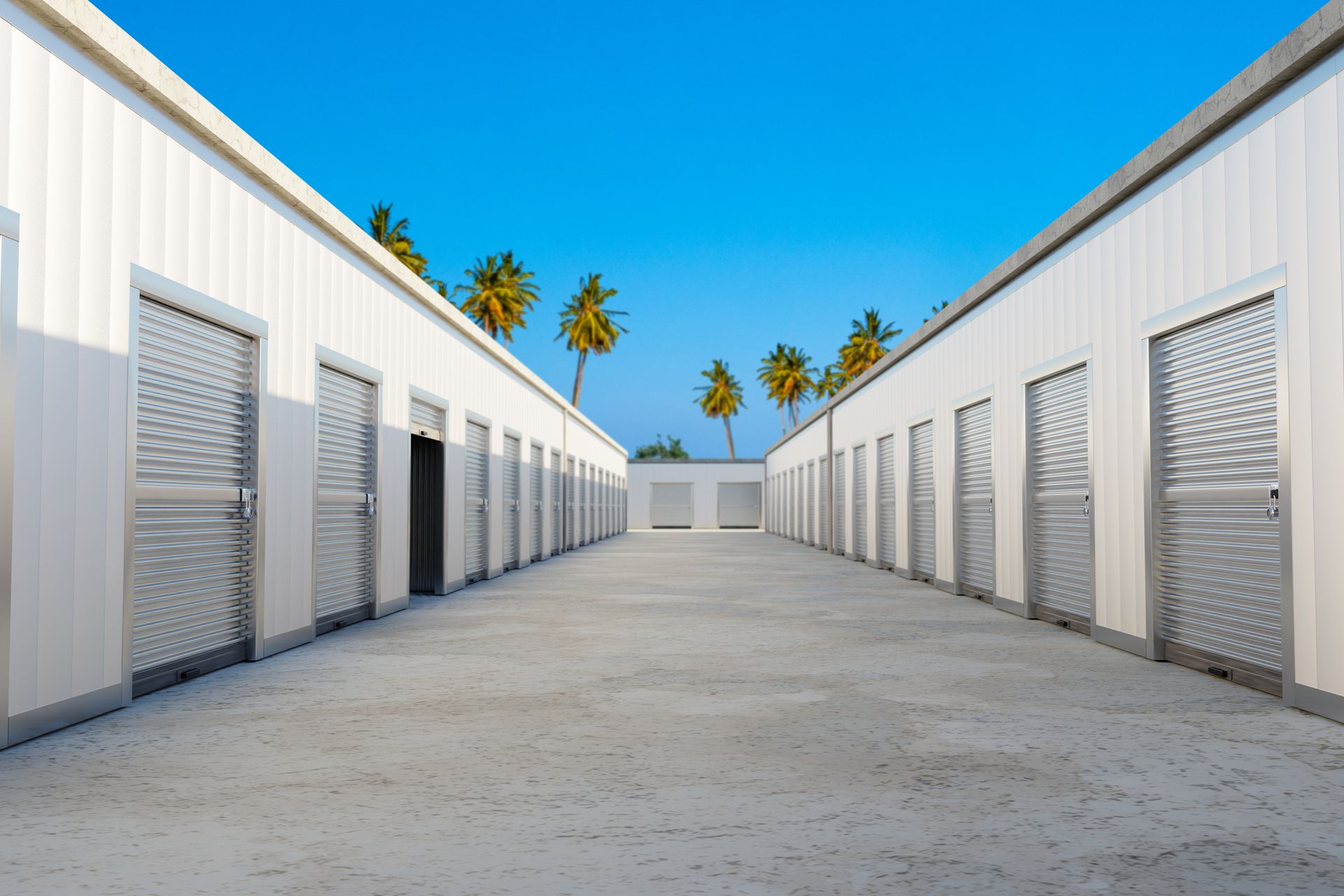 Outdoor self-storage facility with rows of white storage units and roll-up doors. Outdoor self-storage facility with rows of white storage units and roll-up doors.