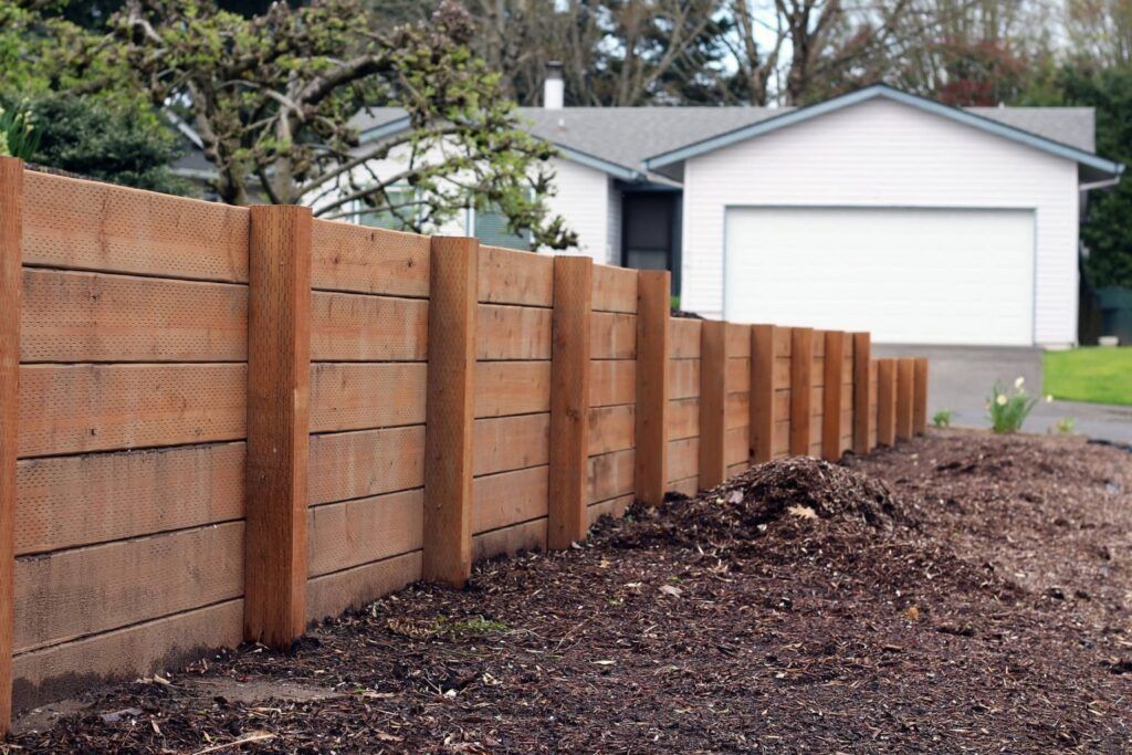 A wooden fence in front of a white house