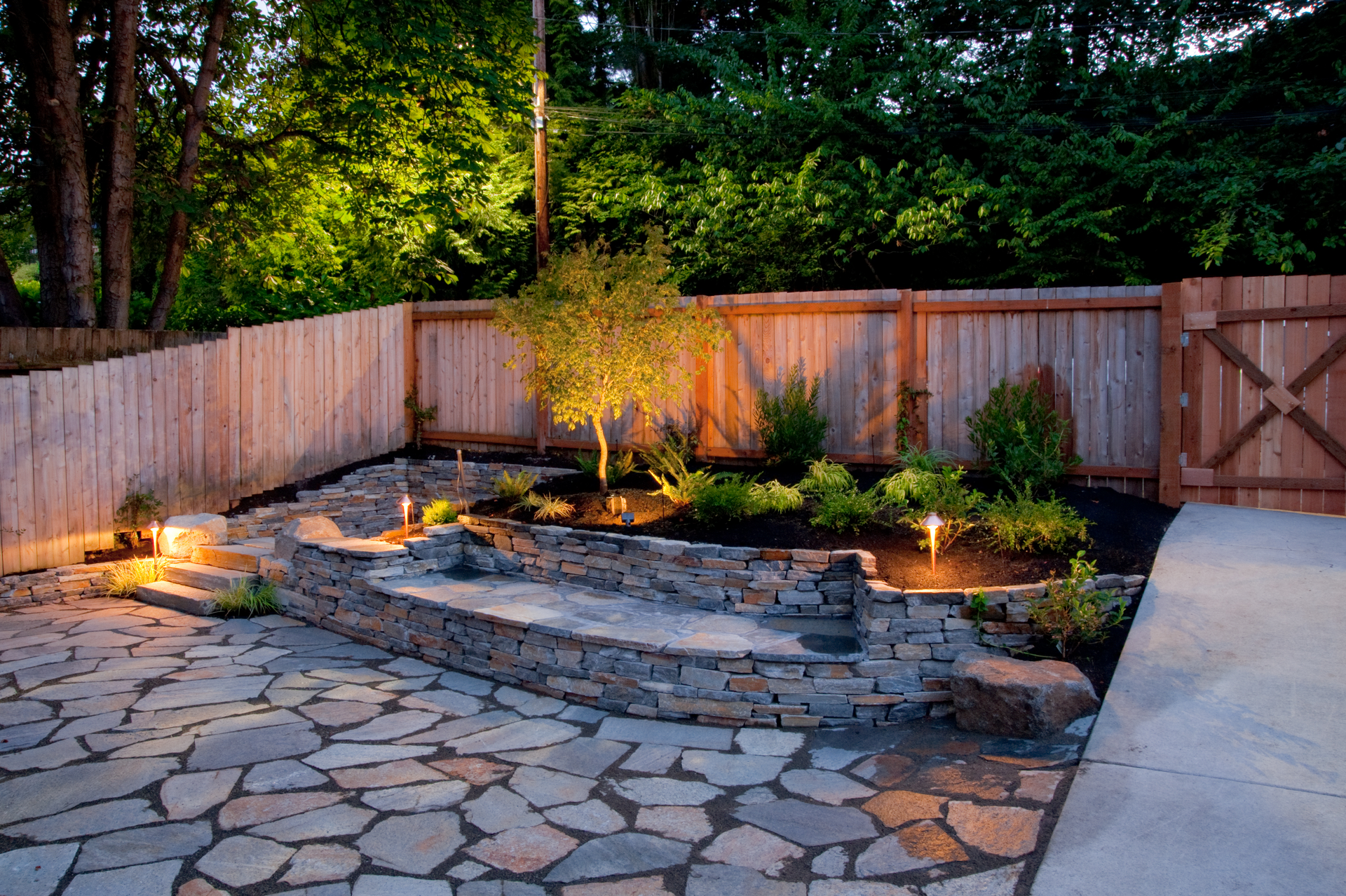A stone patio with a wooden fence in the background