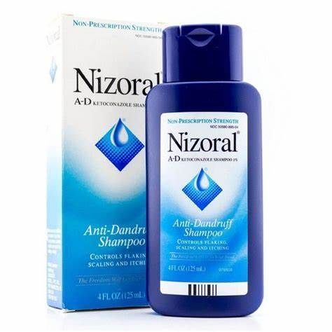 A bottle of nizoral anti dandruff shampoo next to its box.