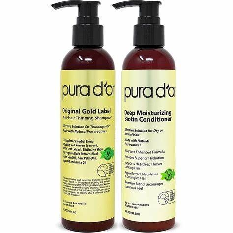 Two bottles of pura d ' or deep moisturizing biotin conditioner and shampoo.