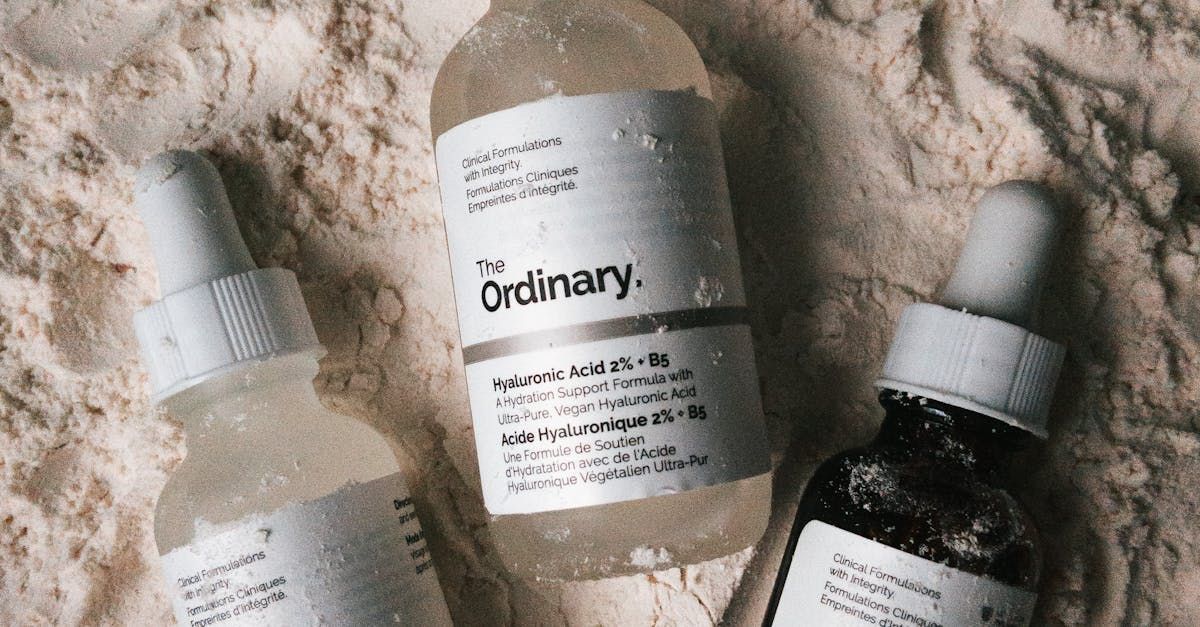 Three bottles of the ordinary are sitting on top of a pile of sand.