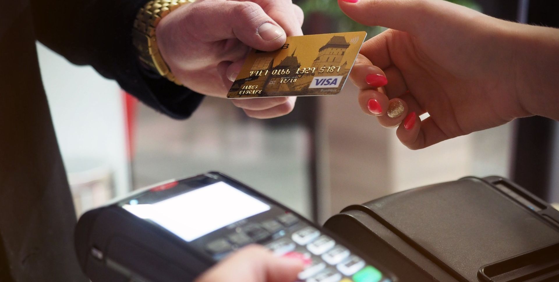 a man is paying with a credit card at a machine after hair transplant.