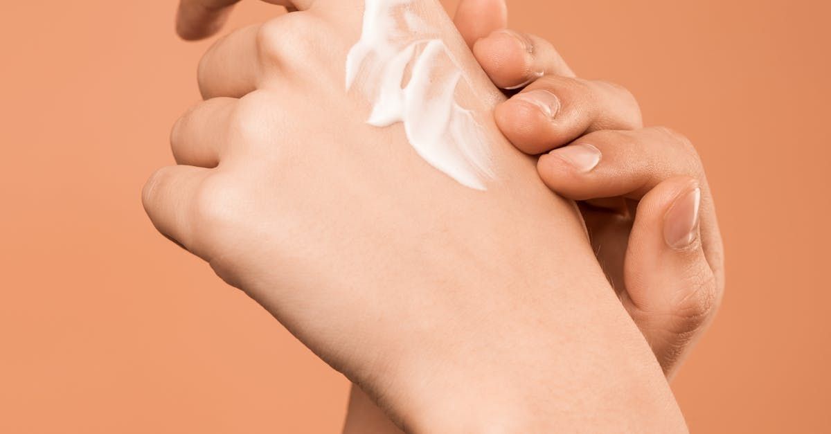 A woman is applying lotion to her hand.
