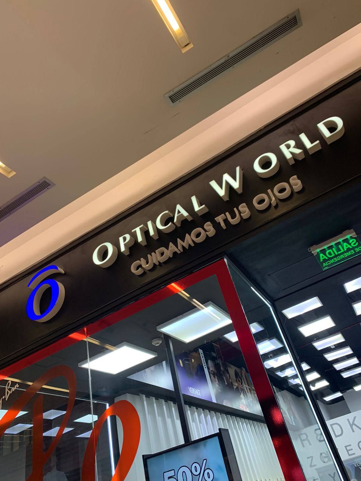 Letrero de la tienda “OPTICAL WORLD” con entrada enmarcada en rojo en el pasillo de un centro comercial.