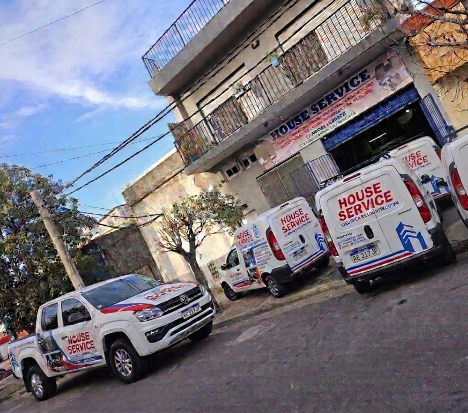 Tres furgonetas blancas de servicio estaban aparcadas frente a un edificio con un cartel que decía