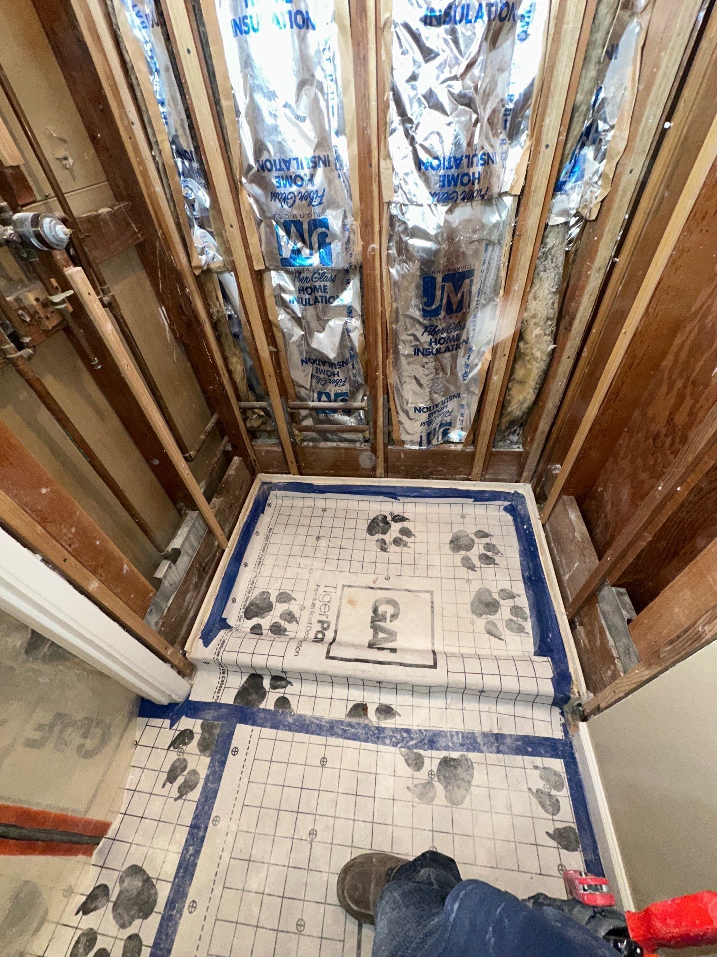Exposed plumbing and wood framing beneath a sink, with a yellow-circled pipe joint.