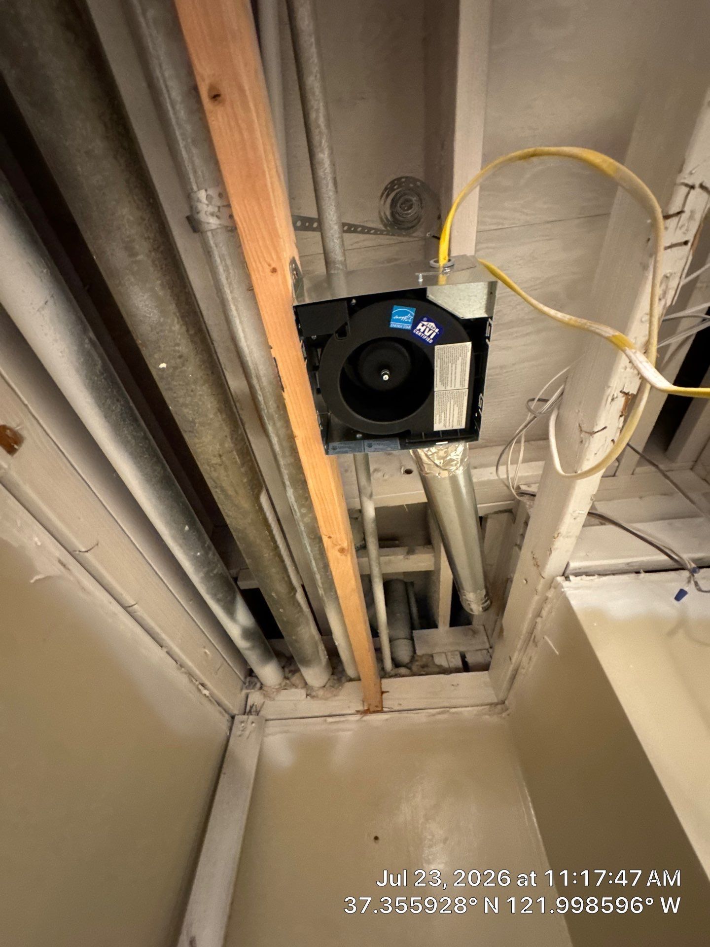 Attic roof framing with wooden beams, rafters, and blue insulated ducting overhead