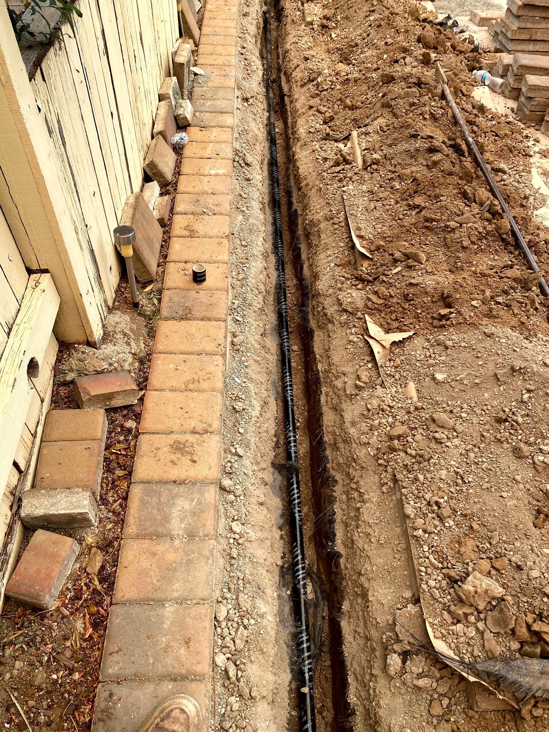 Hand holding a digital meter over a wooden floor with measuring sticks nearby