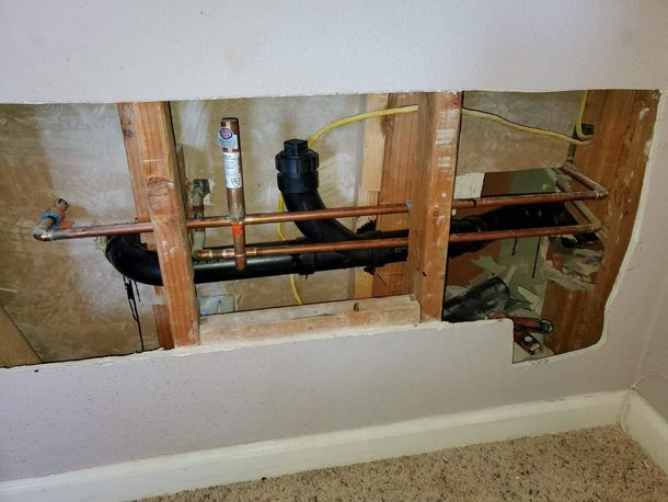 Open ceiling hatch with exposed white beams and a doorway below