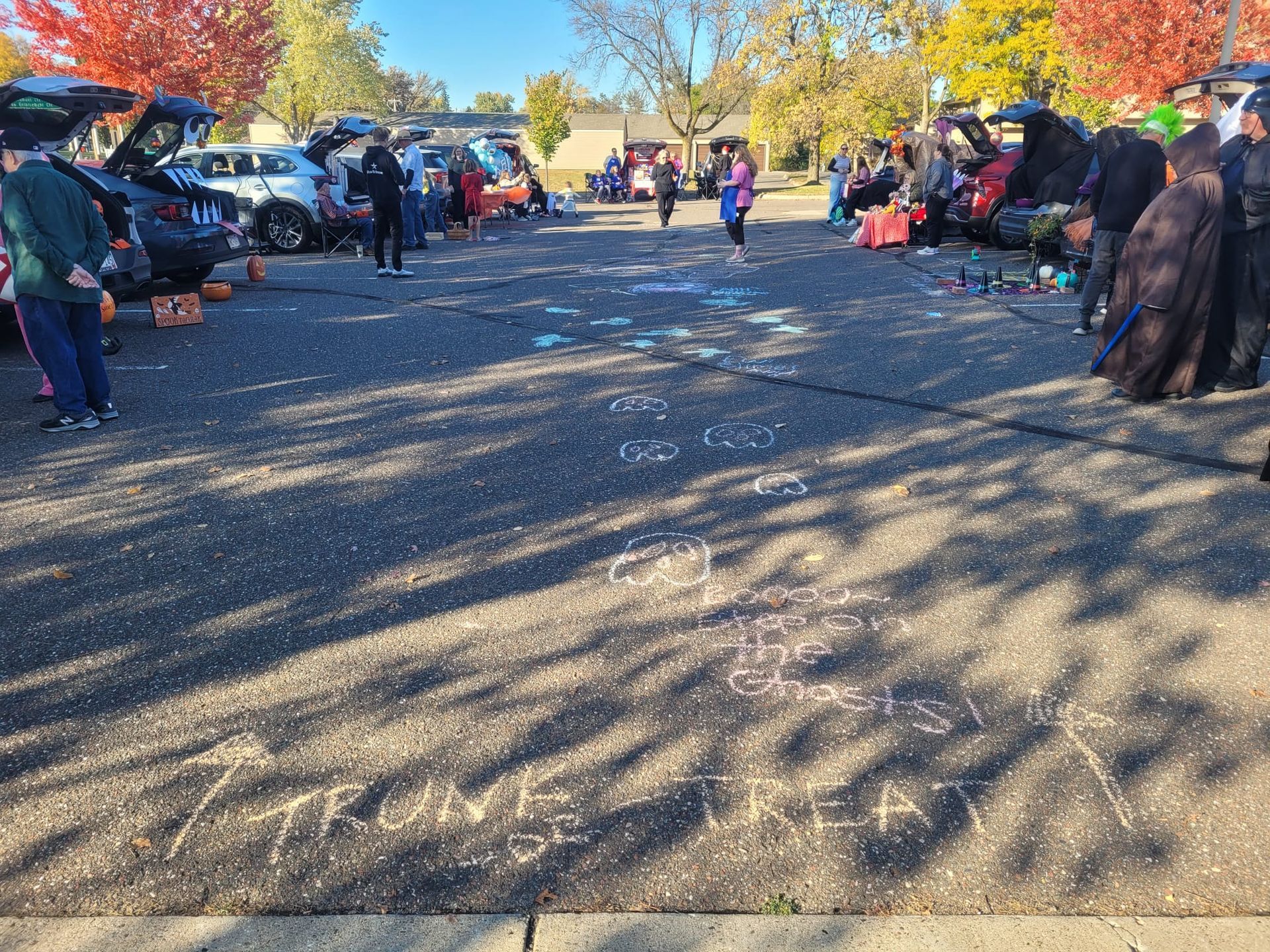 decorated vehicles lining a parking lot ready to hand out candy for Trunk or Treat