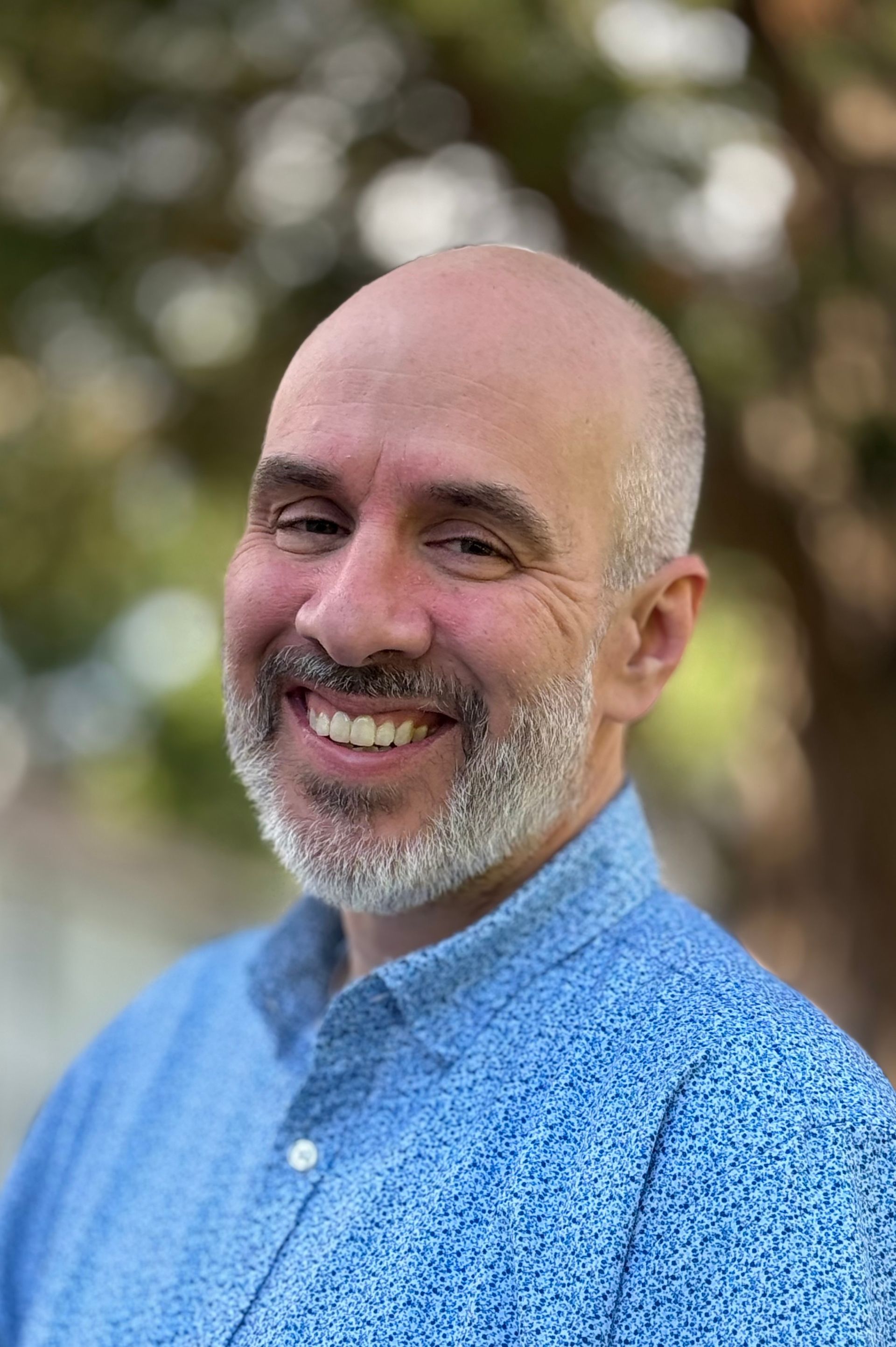 A man with a beard is smiling for the camera.