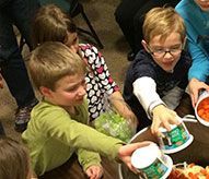 A group of children are sitting around a table eating food.