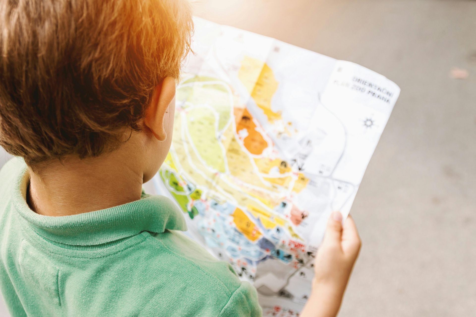 A young boy is looking at a map of the world.