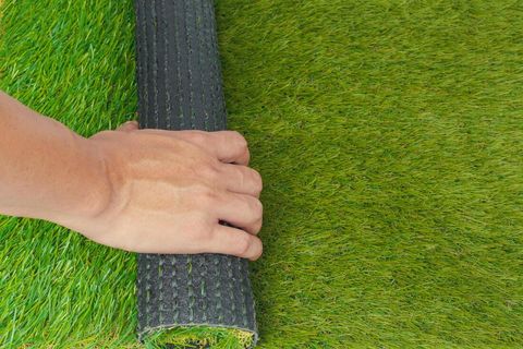 Artificial lawn being rolled out during an installation in Sheffield